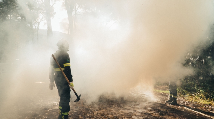 Two firefighters in a cloud of smoke 