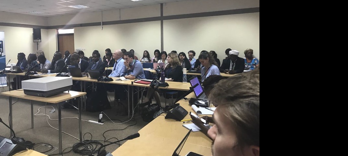 Delegates sitting in a meeting room and listening to a presentation