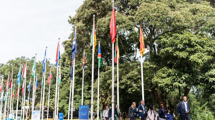 Man and women walk beside flag poles.