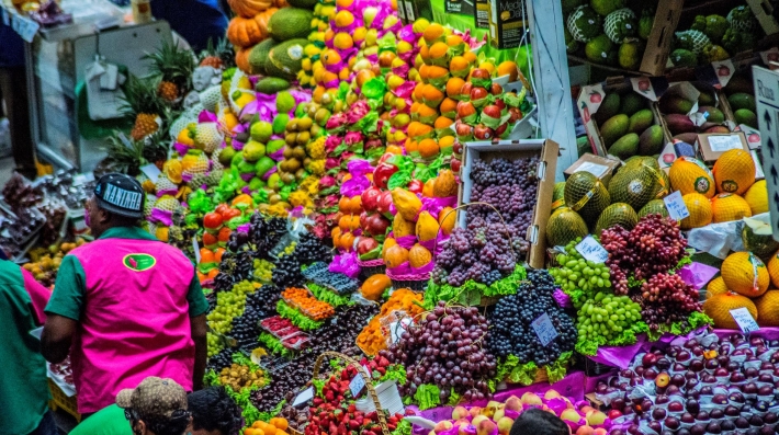 Colourful fruits displayed in a Brazilian marketplace, including strawberries, grapes and oranges. 