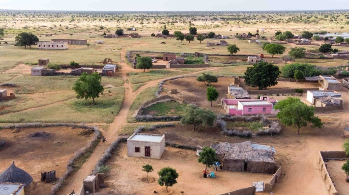 An aerial view of Nima Elmassad’s home in Um Naam Um village in Sudan’s White Nile state, as she sits in the shade of a recently planted fruit tree.