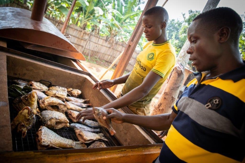 Two men cooking fish.