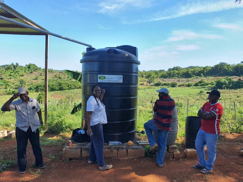 People standing around water tank