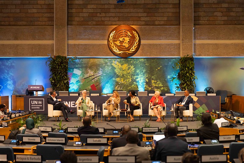 Women and men at a panel in a conference room 