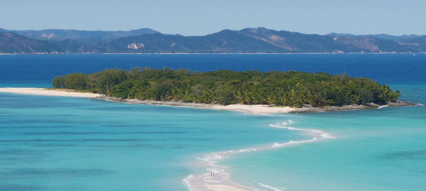 Photo of island with trees surrounded by blue water